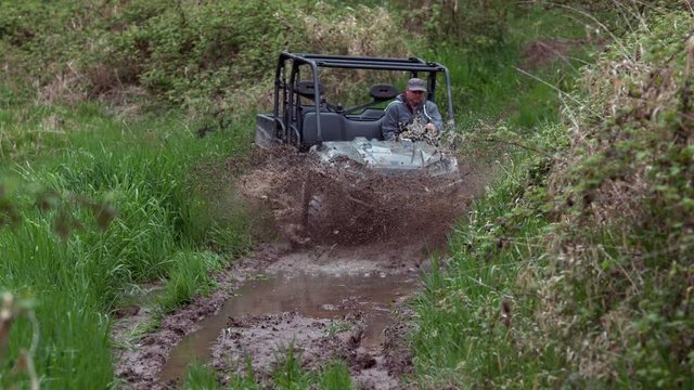 Man drives atv through mud, slow motion
