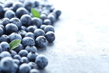 Ripe and tasty blueberries on grey wooden table