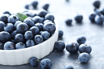 Ripe and tasty blueberries on grey wooden table