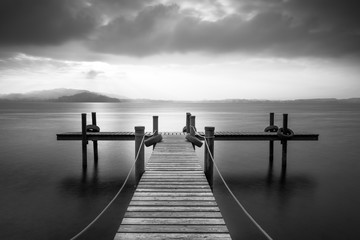 Jetée en bois sur le lac de Zoug, Suisse. Exposition longue. Noir et blanc.