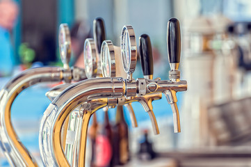 Draught beer taps in a bar.