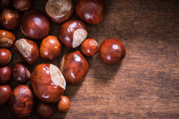 Autumn chestnuts on wooden background
