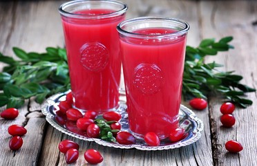 fruit drinks from a cornel on the old wooden background.