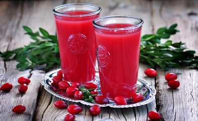 fruit drinks from a cornel on the old wooden background.