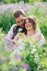 portrait of the bride and groom resting on a lavender background