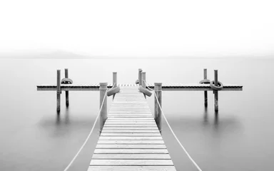 Foto op Aluminium Zwart wit Houten pier op het meer. Mist. Lange blootstelling. Zwart en wit.