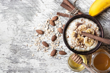 fresh oatmeal porridge with banana, honey, nuts and spices