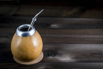 Yerba mate with bombilla on wooden background