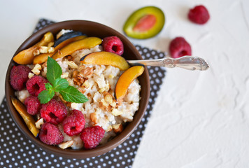 Oatmeal with berries, plums, nuts and honey for breakfast