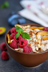 Oatmeal with berries, plums, nuts and honey for breakfast