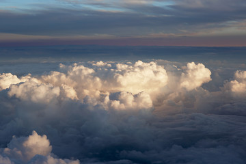 Aerial view of thick clouds over the land, the landscape. The texture of the scenic sky during sunset.