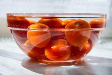 Tomatoes in a bowl full of water.