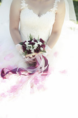 a bride holding a red and white wedding bouquet of flowers