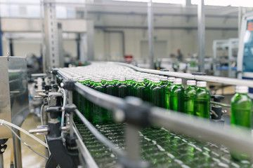 Naklejka premium Water factory - Water bottling line for processing and bottling pure spring water into green glass small bottles.