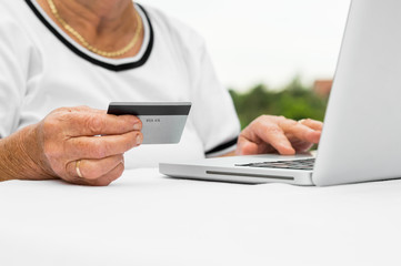 Grandmother buying online with credit card, typing info