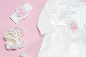 Clothes for baby girl on a pink background. Copy space