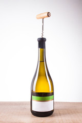bottle of white wine and a corkscrew for wine