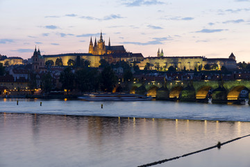 Fototapeta na wymiar Colorful Prague gothic Castle above the River Vltava with Charles Bridge after Sunset, Czech Republic