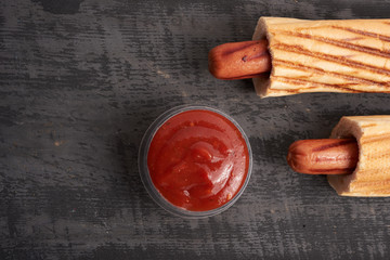 two hot dogs and ketchup on the table