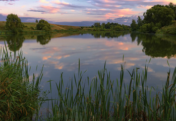 Fototapeta na wymiar Вечерний пейзаж с видом закатного неба и озера 