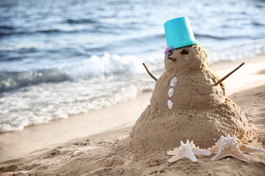 Snowman made of sand on beach