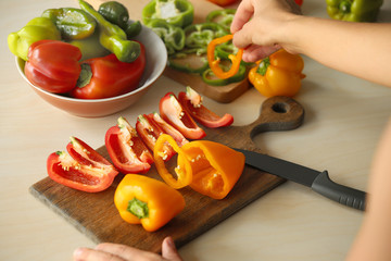 Woman preparing peppers in kitchen