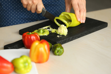 Woman preparing peppers in kitchen