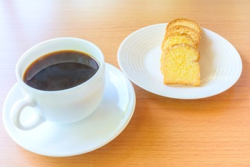 Coffee and butter bread on wooden table