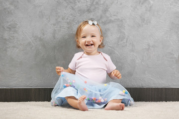 Fototapeta premium Little fashion-girl posing on a gray wall background