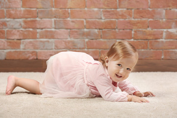 Little  fashion-girl  in pink dress posing on a brick wall background