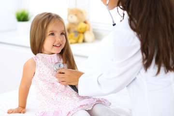 Obraz na płótnie Canvas Doctor examining a little girl by stethoscope