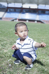 Cute Chinese baby boy playing in a stadium