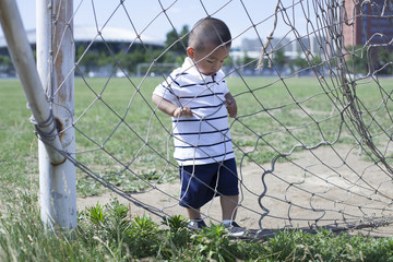 Cute Chinese baby boy playing in a stadium