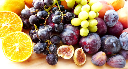 Slices of orange and fig fruits, grapes and plums