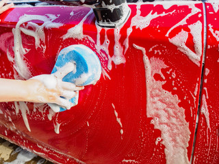 man hand hold sponge for washing car