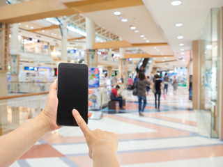Woman's hands using smartphone in shopping mall