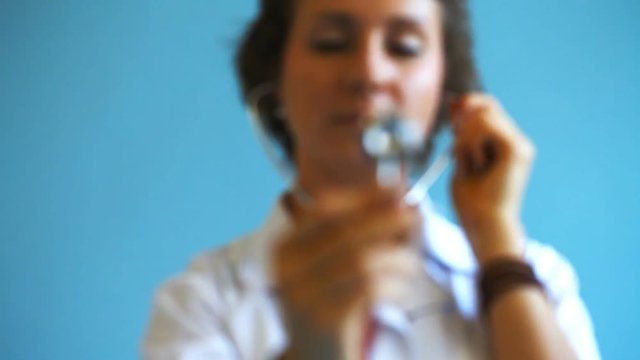 Young woman doctor with stethoscope in studio