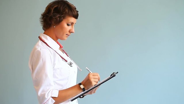 Young woman doctor with stethoscope in studio