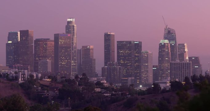 LOS ANGELES, CA, USA  - AUGUST 2016: Tilt up from dark hills to reveal the Los Angeles Downtown skyline at dusk.