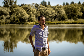 Fototapeta premium young guy on the pier wearing shirt and shorts