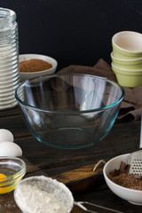 Empty glass bowl with ingredients for cooking chocolate cake