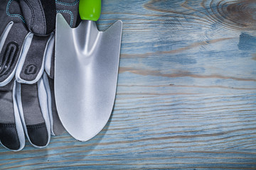 Set of protective gloves hand shovel on wooden board gardening c