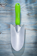 Stainless hand spade on wooden board gardening concept