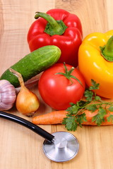 Fresh vegetables and stethoscope on wooden surface, healthy lifestyle and nutrition