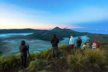 Photographer is taking photo during sunrise at mountain Bromo, Indonesia