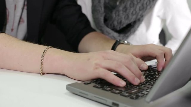 Man's hands typing on a laptop keyboard.