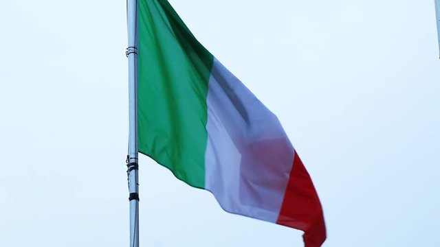 Italian flag on a flagpole blowing in the wind