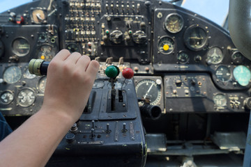 Fototapeta premium Vintage airplane dashboard with hand pushing leverer, shallow focus on hand