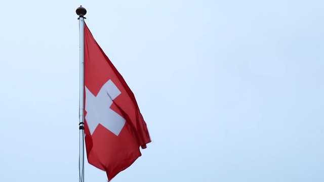 Switzerland flag on a flagpole blowing in the wind