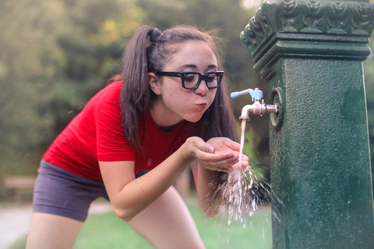 Thirsty Teenager Drinking Water At The Park